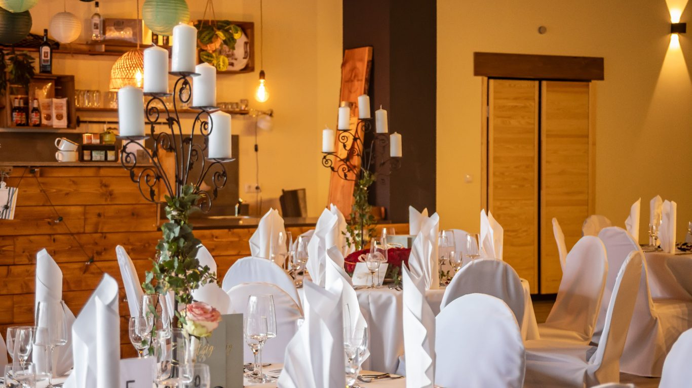 Elegant Restaurant mit gedeckten Tischen und weißer Dekoration.