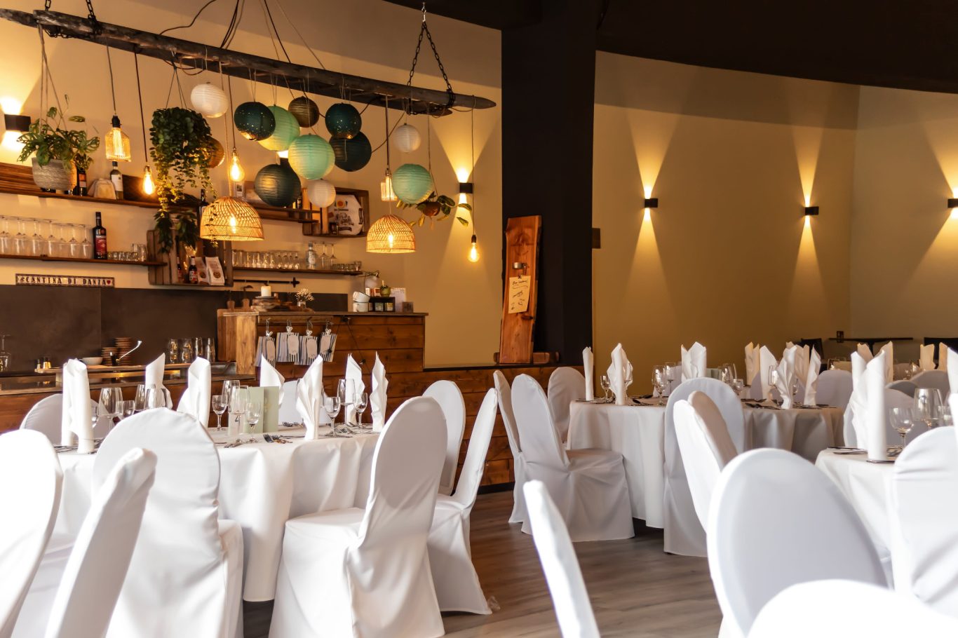 Elegant Restaurant mit runden Tischen, weißen Tischdecken und stilvoller Beleuchtung.